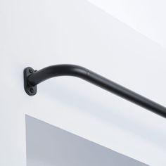 a black handle on the side of a white wall