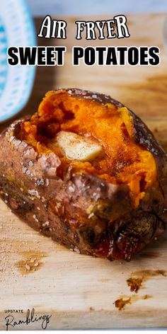 a baked potato sitting on top of a wooden cutting board next to a blue and white plate