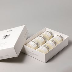 six bottles of soap in a white box on a gray surface with the lid open