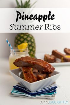 pineapple summer ribs in a white bowl on a blue and white napkin next to a pineapple