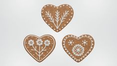 three heart shaped cookies decorated with white flowers