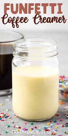 a glass jar filled with coffee creamer and sprinkles on the table