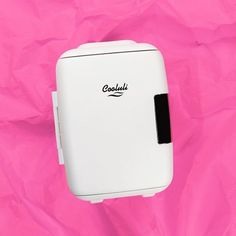 a white toaster sitting on top of a pink sheet