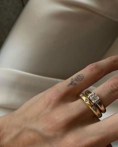 a woman's hand with two wedding rings on it