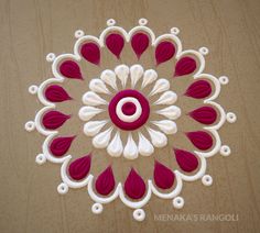 a red and white circular design made out of paper on top of a wooden table