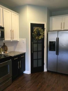 a kitchen with white cabinets and stainless steel appliances