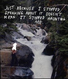 a man standing on top of a rock next to a river