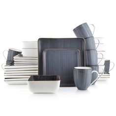 a stack of plates, cups and saucers on a white surface