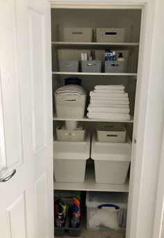 the closet is filled with white containers and plastic bins