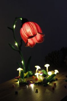 a flower that is sitting on a table with some lights in the dark behind it