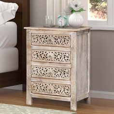 a white wooden dresser sitting next to a bed