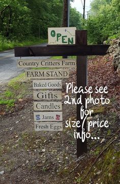 a wooden cross sitting on the side of a road next to a sign that says country critters farm