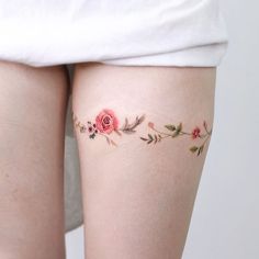 a woman's thigh with flowers and leaves on it