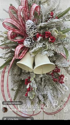 a christmas wreath with two bells hanging from it's center and pine cones on top