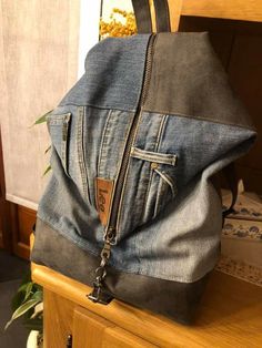 a denim backpack sitting on top of a wooden table