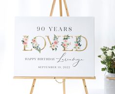 a sign that says 90 years loved with flowers on it and the words happy birthday