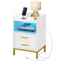 a night stand with a phone on it and a lamp next to it that is plugged in