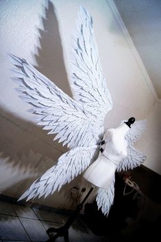 a white bird made out of paper sitting on top of a table