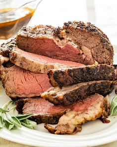 sliced roast beef on a plate with herbs