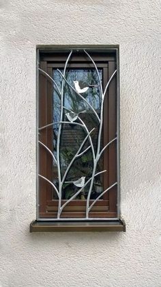 there is a window with birds on the tree branches in it and one bird sitting on the branch