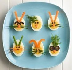 deviled eggs decorated as bugs and carrots on a blue plate