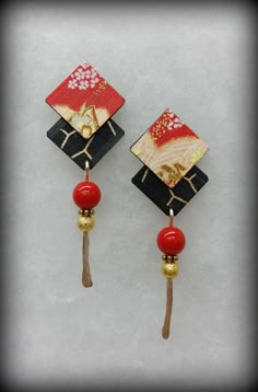 two red and black earrings with gold accents