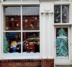 a store front window decorated with christmas decorations and cartoon characters on the windows sill