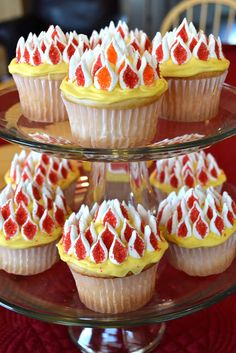 cupcakes with white and red frosting on a glass plate