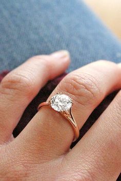 a close up of a person's hand with a diamond ring on their finger