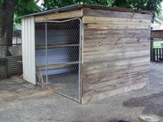 a dog kennel made out of wood and metal with an open door on the side