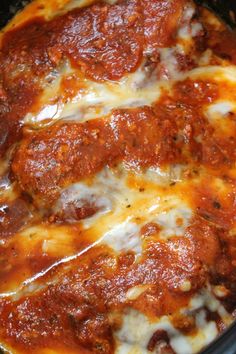 a close up view of a pizza in a crock pot with cheese and sauce