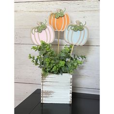 three decorative pumpkins sitting on top of a planter