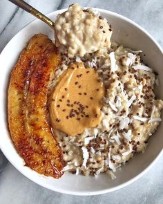 a bowl filled with bananas and rice covered in peanut butter