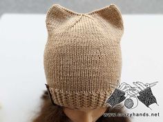 a doll wearing a knitted cat hat