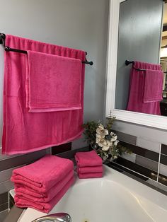 a bathroom with pink towels hanging on the wall