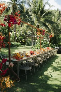 a long table with flowers and candles on it in the middle of a lawn area