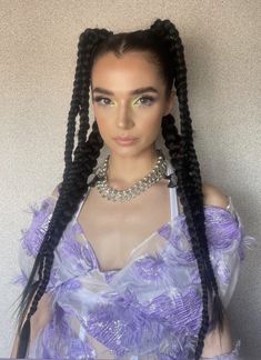 a woman with long braids wearing a purple dress