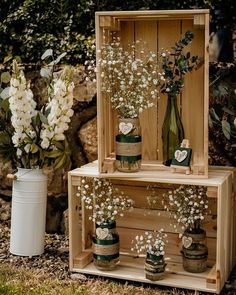 two wooden crates with vases and flowers in them sitting on the ground next to each other