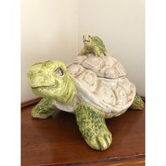 a turtle statue sitting on top of a wooden table