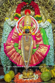 the idol is surrounded by fruit and flowers