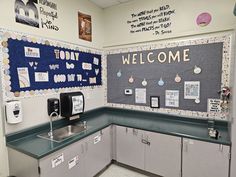 a welcome sign is posted on the wall in a kitchen area with green counter tops and gray cabinets