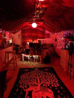 the room is lit up with red lights and decorations on the ceiling, along with an elephant rug