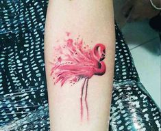 a pink flamingo tattoo on the arm