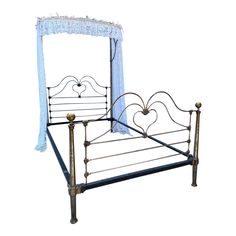 a metal bed with a blue canopy and white curtains on the headboard, against a white background