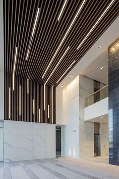 the interior of a building with marble floors and walls, along with wooden slats