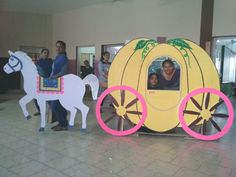 two people standing next to a fake horse and buggy that is made out of cardboard