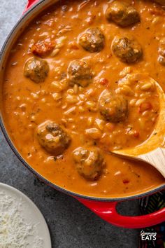 a red pot filled with meatballs and sauce