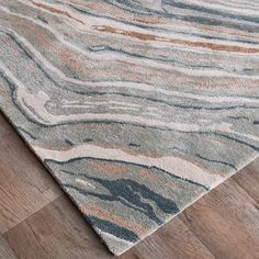 an area rug with wood flooring and marble pattern on the top, along with wooden floors