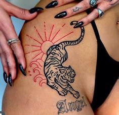 a woman with tattoos on her stomach has a tiger tattoo on the side of her belly