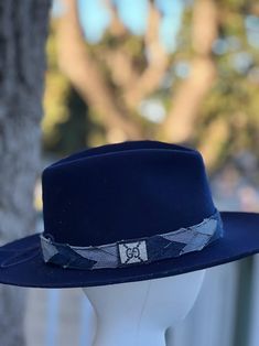 Designer choice!! Take a look at this fun denim blue adjustable hatband with different colors of denim that really make this hatband pop on any style/color of hat. The band is 22.5" x 1.25" and has adjustable navy-blue suede ties in the back so it can fit hats from 22.5-34". The band is secured by two gold tie clamps in the back to give it a nice, finished look. The hat band has been sewn together and treated with fray protector to help keep this hatband looking good for years to come. To comple Blue Fedora Hat One Size Fits Most, Casual Blue Fedora With Flat Brim, Adjustable Denim Blue Wide Brim Hat, Adjustable Wide Brim Denim Blue Hat, Denim Blue Wide Brim Hat With Adjustable Fit, Adjustable Blue Felt Hat With Curved Brim, Blue Fitted Fedora Hat, Casual Adjustable Blue Fedora, Denim Blue Brimmed Hat, One Size Fits Most